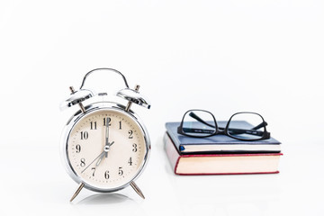  Alarm clock with old book with eyeglasses