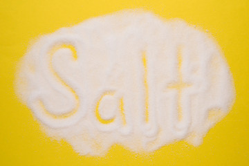 salt word on yellow background. Concept of food ingrediennt, cooking and health care