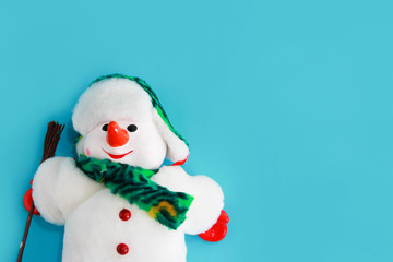 Christmas decorative toy snowman in a white fur coat and hat on a blue background for the New Year holiday