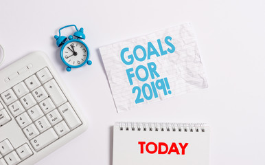 Text sign showing Goals For 2019. Business photo showcasing object of demonstratings ambition or effort aim or desired result Blank paper with copy space on the table with clock and pc keyboard