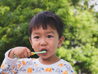 Asian young kid brush teeth by self at home in the morning.