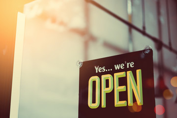 Open sign hanging front of cafe with colorful bokeh light abstract background.