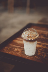 Ice coffee on wood table in cafe shop.