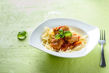 homemade pasta with tomato sauce and cooked meatballs