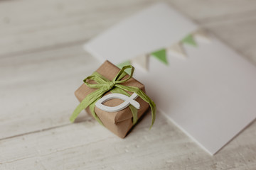 Religion, Glaube - Geschenk mit recyclingpapier, grüner Schleife und weißem Fisch