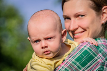 Close-up of a young mother holding a small baby in her arms