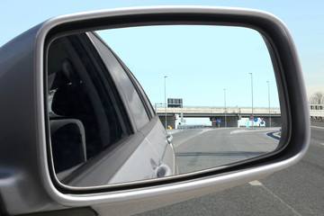 Fototapeta premium close up on a rear external car rear mirror and an highway interchange reflected in