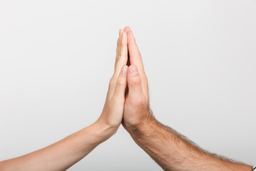 Man's and woman's hands give a high five to each other isolated over white wall background.