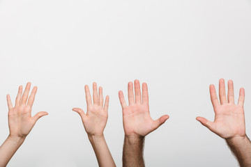 Man's and woman's raised hands isolated over white wall background.