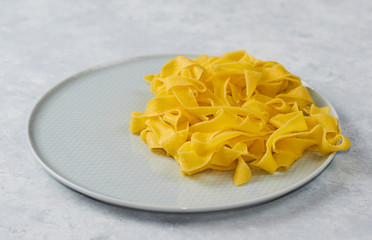 freshly prepared pasta on a blue plate, on a blue background. Italian cuisine.