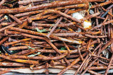 Background in the form of a heap of old rusty nails and brown screws, top view