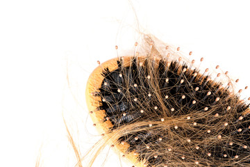 Wood hairbrush on white background. Close-up with long brown hair