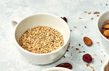 Raw oatmeal in a ceramic cup on the table. Healthy food