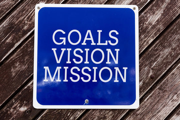 Handwriting text writing Goals Vision Mission. Conceptual photo practical planning process used to help community group Empty blue board with copy space above wooden background