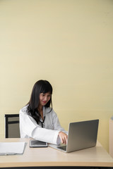 The happy female doctor sat on the working chair in the examination room
