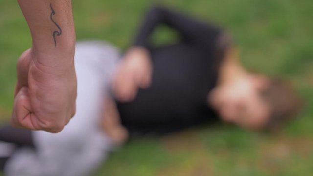 defocused defenseless scared pregnant woman on ground after being beaten by man