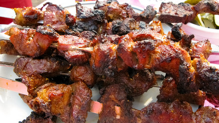 Roasted meat on skewers close-up lies on the table