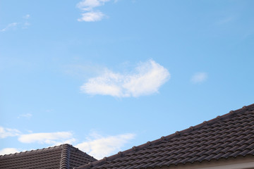 Fototapeta na wymiar tiles roof on new house with blue sky