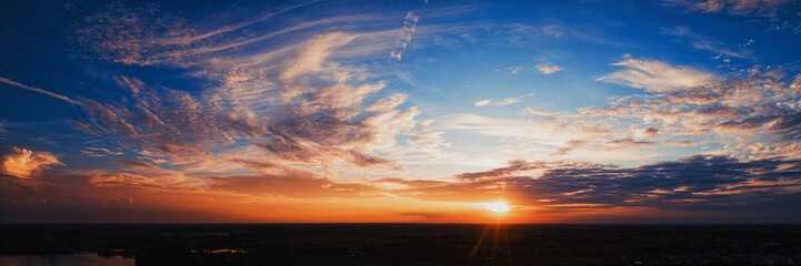 Wide panorama of sunset sky with clouds and sunlight over farm - obrazy, fototapety, plakaty