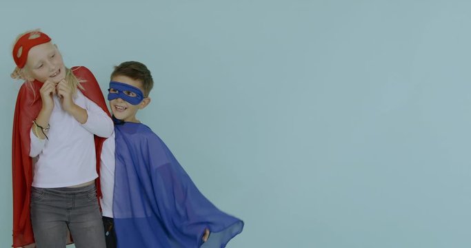 120 FPS SLOW MOTION Cute funny little Caucasian kids boy and girl wearing capes and masks pretending to be superheroes. 4K UHD