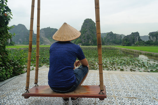 Turista admirando la vista panoramica de las monta&ntilde;as karsticas y campos de arroz desde la cima de Hang Mua Peak en Tamc Coc, provincia de Ninh Minh en Vietnam