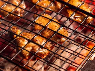 Pickled chicken wings are cooked over an open fire while lying in the grill.