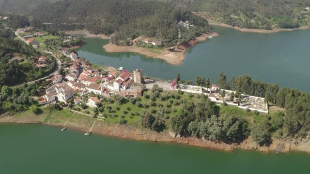 Aerial drone view of Dornes in Portugal and a boat sailing on river Zezere