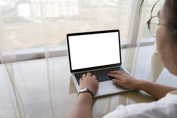 Close-up image of a business woman's hands are using Laptop computer with blank screen on wood table, business concept. design with copy space.