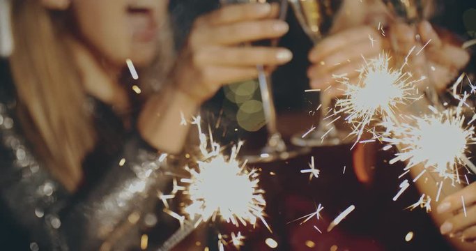 Close friends meeting xmas and drink chamagne with sparklers in hands. Christmas, friendship, vacation, lifestyle, advertising, commercial concept. Close shot on 4k RED camera with 12 bit color depth.
