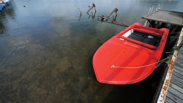 Old Red Boat in lake on Summer Sunny day.