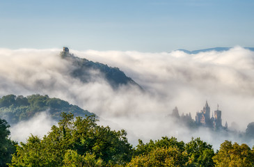 Autumn fog in Nature Park Siebengebirge (Seven Mountains) arose from the river Rhine valley, view of the hill Drachenfels (Dragon's Rock) with the castle ruin and Drachenburg, NRW, Germany