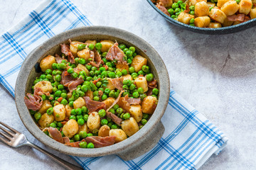 Potato gnocchi with green peas, pesto, proscuitto and chorizo in a bowl