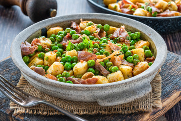 Potato gnocchi with green peas, pesto, proscuitto and chorizo in a bowl