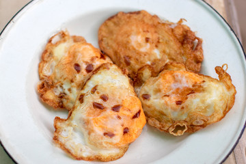 Fried egg on white plate with sauce.