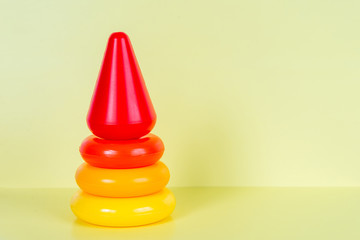 Early learning. Colorful geometric logic toy for geeks pyramid isolated on yellow background....