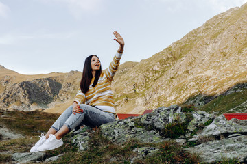 woman standing with hands up achieving the top. Girl welcomes a sun. Conceptual design. Successful woman hiker open arms on sunrise mountain top. Girl in long white dress in the mountains.