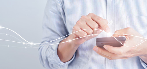 close up young man holding smartphone and using high speed internet for download or upload data package on cyber network with virtual interface futuristic technology for smart life concept