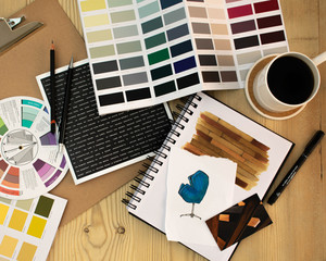 Flat lay of Interior designer work space with sketches, tools and colour chart