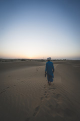 Fototapeta na wymiar uomo nel deserto al tramonto