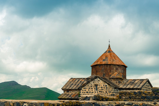 Sevanavank Monastery on a background of dark blue rain clouds, a landmark of Armenia