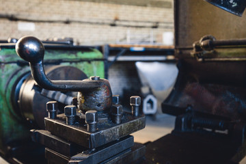 Rusty mechanisms and tools in the shop of an old abandoned factory.