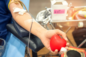 Blood donor at donation, transfusion. Closeup blood donor squeezes the bouncy ball in the form of...