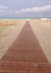 Fototapeta na wymiar wooden walkway that crosses the beach