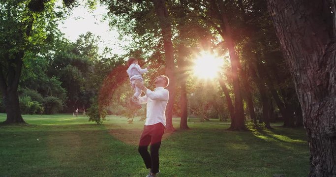 Daddy playing very lovely with his son in the park very charismatic enjoying the time with his little boy they wearing a very stylish clothes