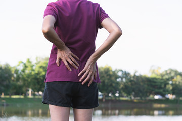 Closeup hands of woman touching her back pain in healthy concept on nature background.