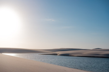 Fototapeta na wymiar Lençois Maranhenses oasis lake in desert with sand dunes colorful sunset