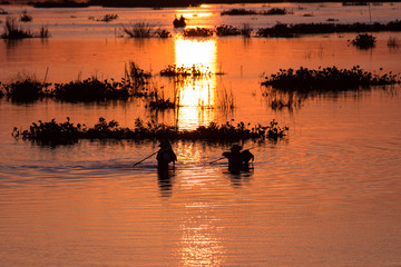 Men fishing on the Lake at sunset scene