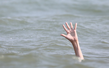bather holds up his hand for help