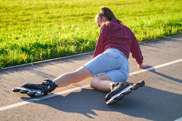 Woman fell on asphalt while rollerblading. Inline skating without protection. Injury and bruise...