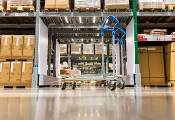 Warehouse storage of retail merchandise shop. Trolley Shopping Cart Between Dry Grocery Shelf Section in Supermarket Warehouse Retail Outlet as Shopping Concept.